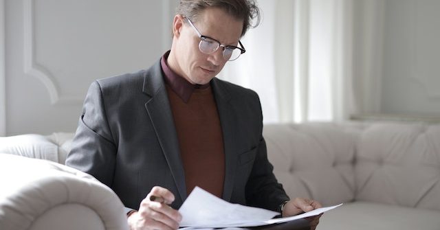 Business man looking at documents on couch