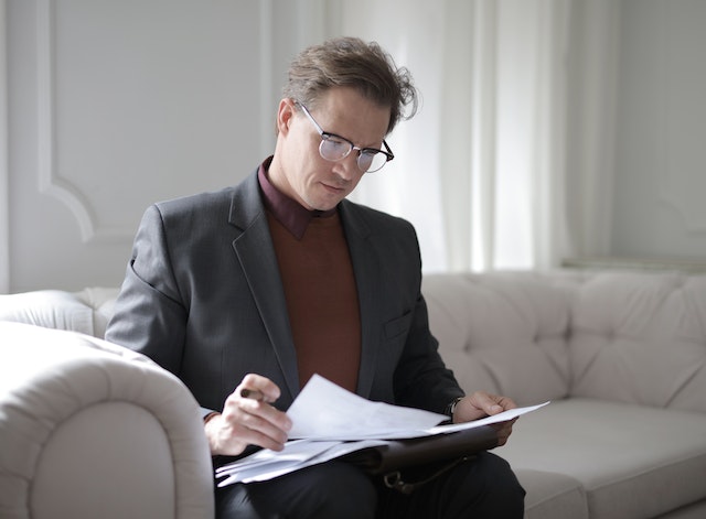 Business man looking at documents on couch
